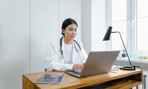 Médica em escritório usando computador